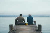 Man and his senior father fishing pier outdoors.