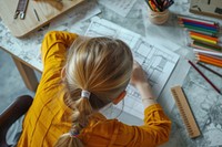 Young girl making architecture drawings on a desktop art handwriting paintbrush.