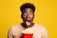 African american guy eating popcorn shock surprised portrait.