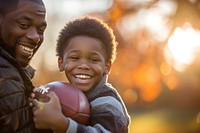 African american boy football laughing sports.