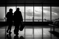 A elderly couple walking at airport silhouette adult infrastructure.