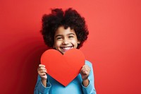 Indian kid holding a paper heart love happiness enjoyment.