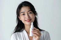 Middle age woman holding a skincare bottle cosmetics portrait smile.