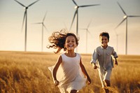 Girl and boy are running in field windmill outdoors happy.
