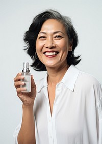 Middle age woman holding a skincare bottle cosmetics laughing portrait.