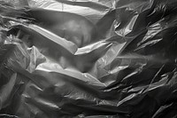 Cling plastic wrap over black background backgrounds monochrome aluminium.