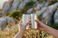 Stainless can  outdoors holding drink.