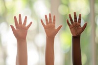 Raise hands of 4 mixed races children finger togetherness gesturing.