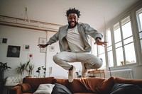 Black man dances in the living room jumping sports adult.