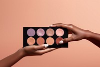 Eyeshadow palette on hand cosmetics holding perfection.