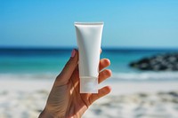 Cream tube cosmetics holding beach.