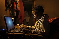 African kid computer sitting working.