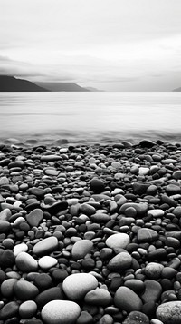 Photography of ocean with beach and stones monochrome pebble rock.