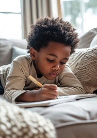 African american kid boy laying at the sofa writing concentration relaxation.