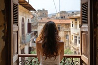 Lebanese female tourist looking at old town balcony architecture building.