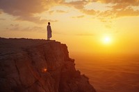 Moroccan man standing on top of cliff at sunset outdoors horizon nature.