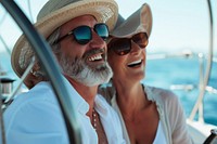 Happy couple on a boat for retirement travel laughing sunglasses portrait.