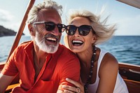 Happy couple on a boat for retirement travel laughing sunglasses portrait.