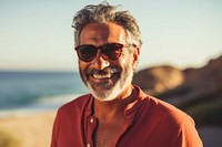 Mature middle eastern man enjoying summer at the beach sunglasses portrait smiling.