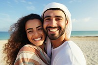 Middle eastern man and woman taking a selfie at the beach sea laughing portrait.
