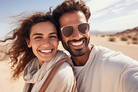 Middle eastern man and woman taking a selfie at the beach laughing smiling glasses.