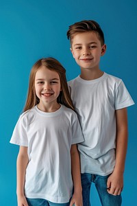 Boy and girl wearing white t-shirts standing toddler smiling.