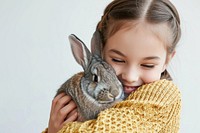 A young girl hugging a rabbit animal mammal child.