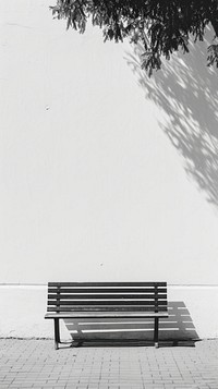 A bench shadow white wall.