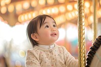Asian toddler carousel cheerful portrait.