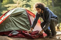 Hispanic man outdoors camping tent.
