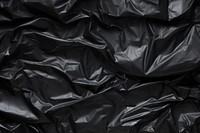  Black crumpled plastic bag backgrounds monochrome wrinkled. AI generated Image by rawpixel.