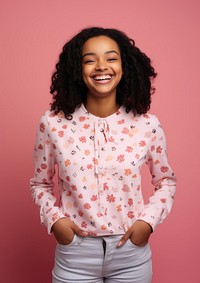 Young African American woman stands smile pattern blouse.