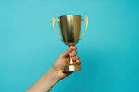 Gold trophy cup holding blue hand. AI generated Image by rawpixel.