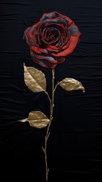 Embroidery with a rose black and gold flower plant inflorescence.