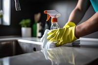 Doing chores in bathroom cleaning sink faucet. 