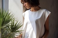 Female wearing  white apron sleeve wall contemplation.