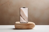 Mobile phone on rustic wood piece podium electronics technology simplicity.