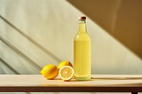 A glass bottle with two lemons sitting on a table fruit food refreshment. AI generated Image by rawpixel.