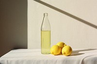 A glass bottle with two lemons sitting on a table fruit plant food. AI generated Image by rawpixel.