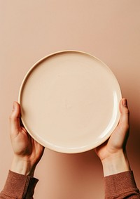 A person holding a plate with a piece of pie on it art tableware porcelain.