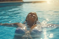 Woman floating in swimming pool recreation sunlight sports. 