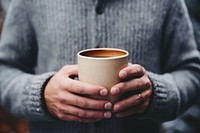 Person holding mug cup beverage coffee.