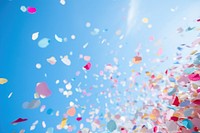 Colorful confetti against clear blue sky outdoors nature petal. AI generated Image by rawpixel.