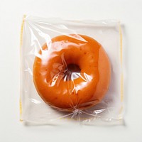 Plastic wrapping over a donut bagel food white background.