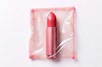 Plastic wrapping over a lipstick cosmetics white background fashion.