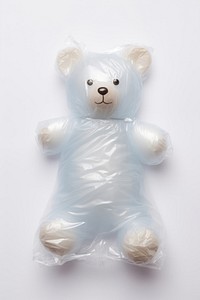 Plastic wrapping over a teddy bear white toy white background.