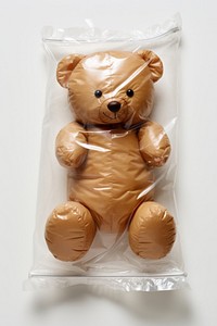 Plastic wrapping over a teddy bear toy white background representation.