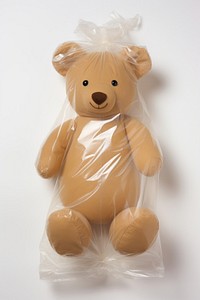 Plastic wrapping over a teddy bear toy white background representation.