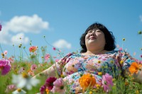 Photo of chubby asian in flower field outdoors summer nature.