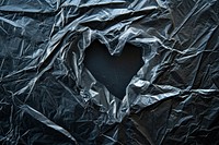 Plastic wrap with heart hole backgrounds black monochrome.